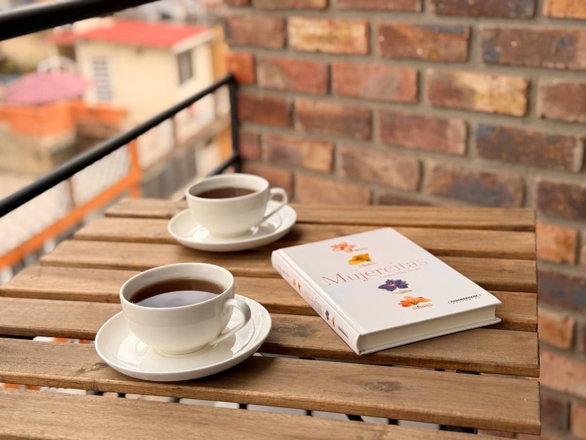 Dos tazas de café y un libro sobre la mesa de madera del balcón